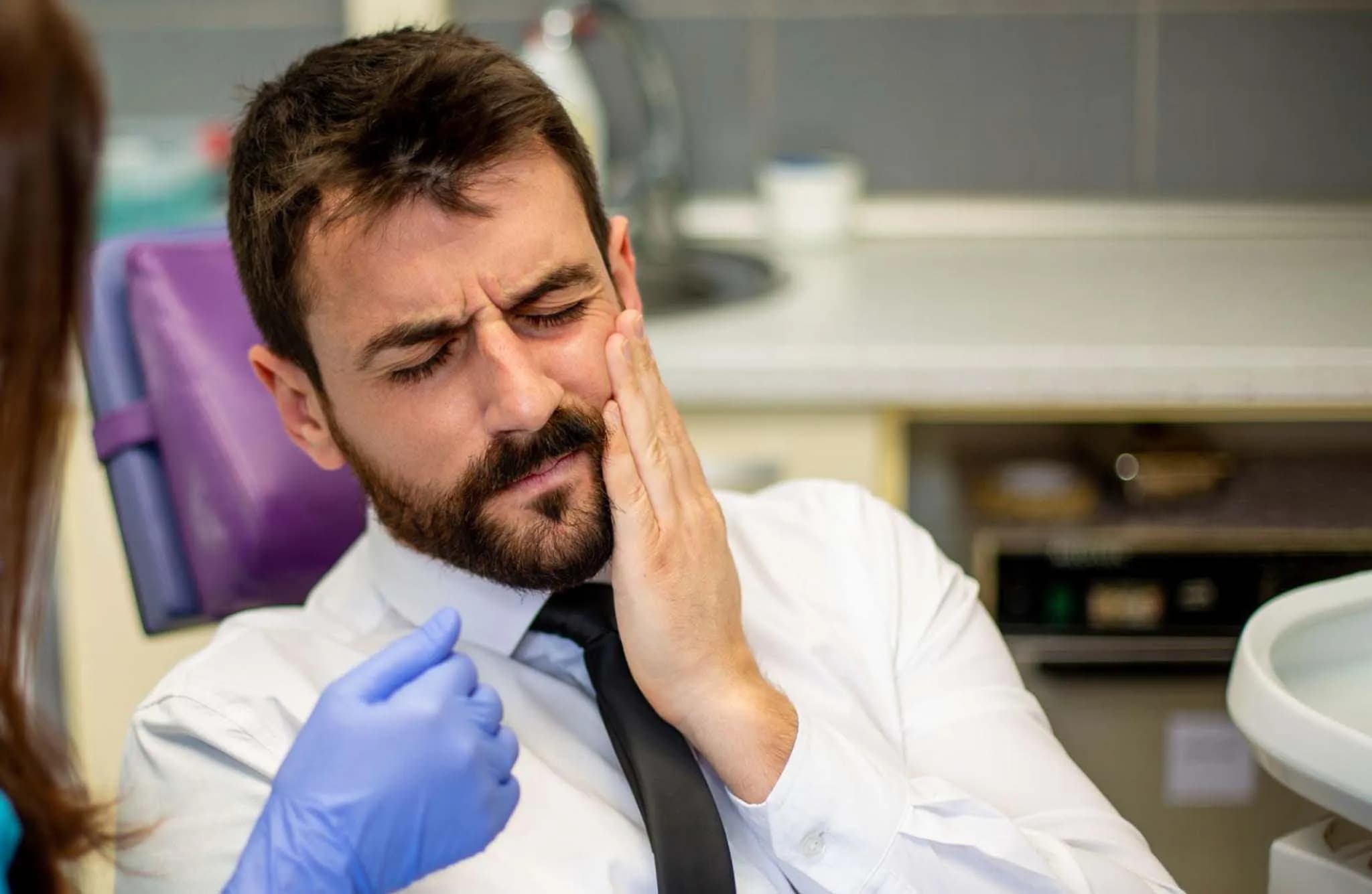 Person experiencing dental pain needing emergency care