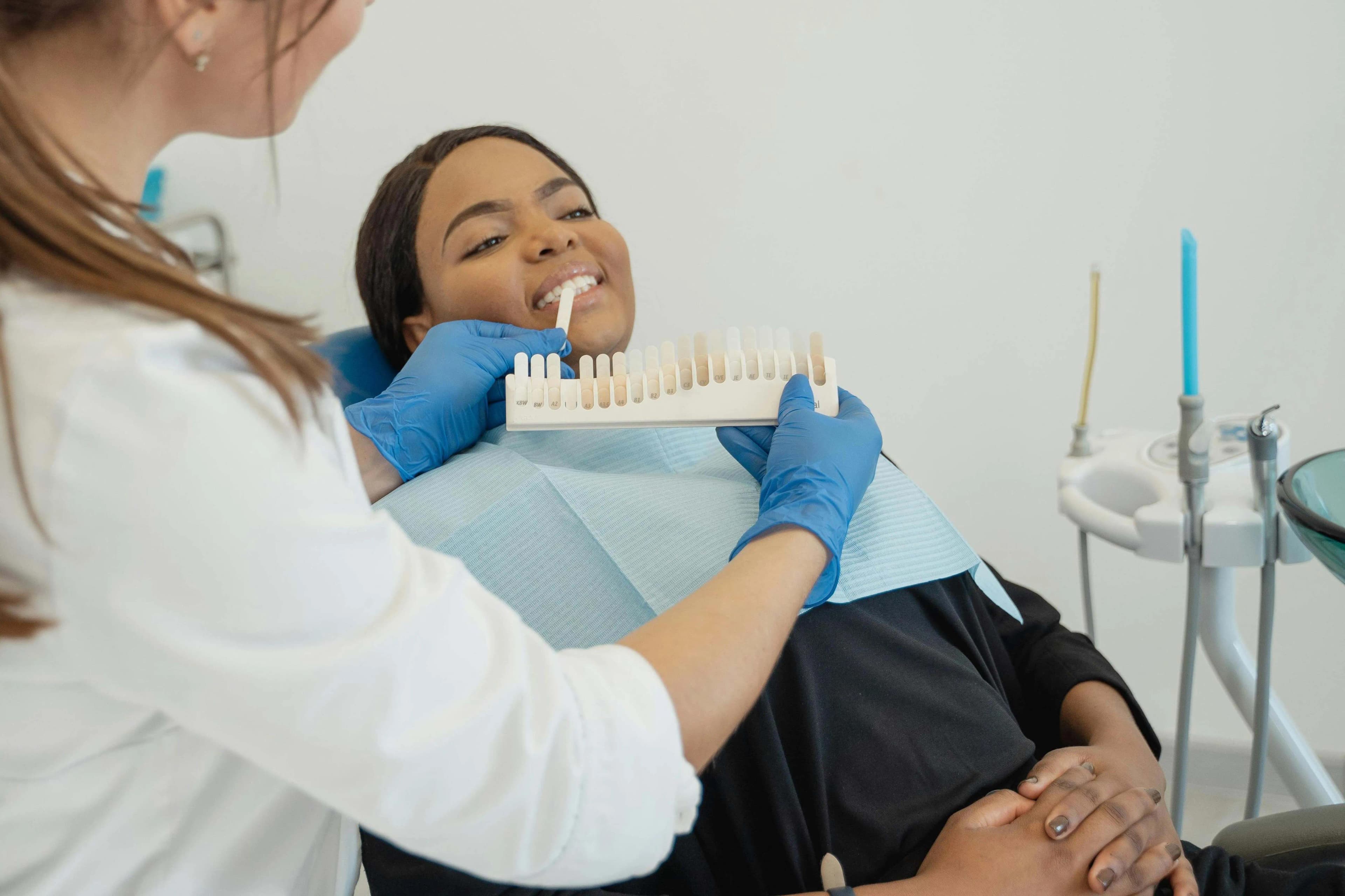 Dentist holding tooth shade guide to assess whitening goals